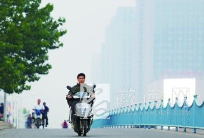 省气象台发布大风蓝色预警 市民骑车开始换上保暖装备