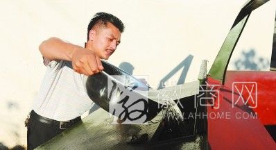 庐江县城管队长自制新式清扫车 王国峰在为清扫车加水